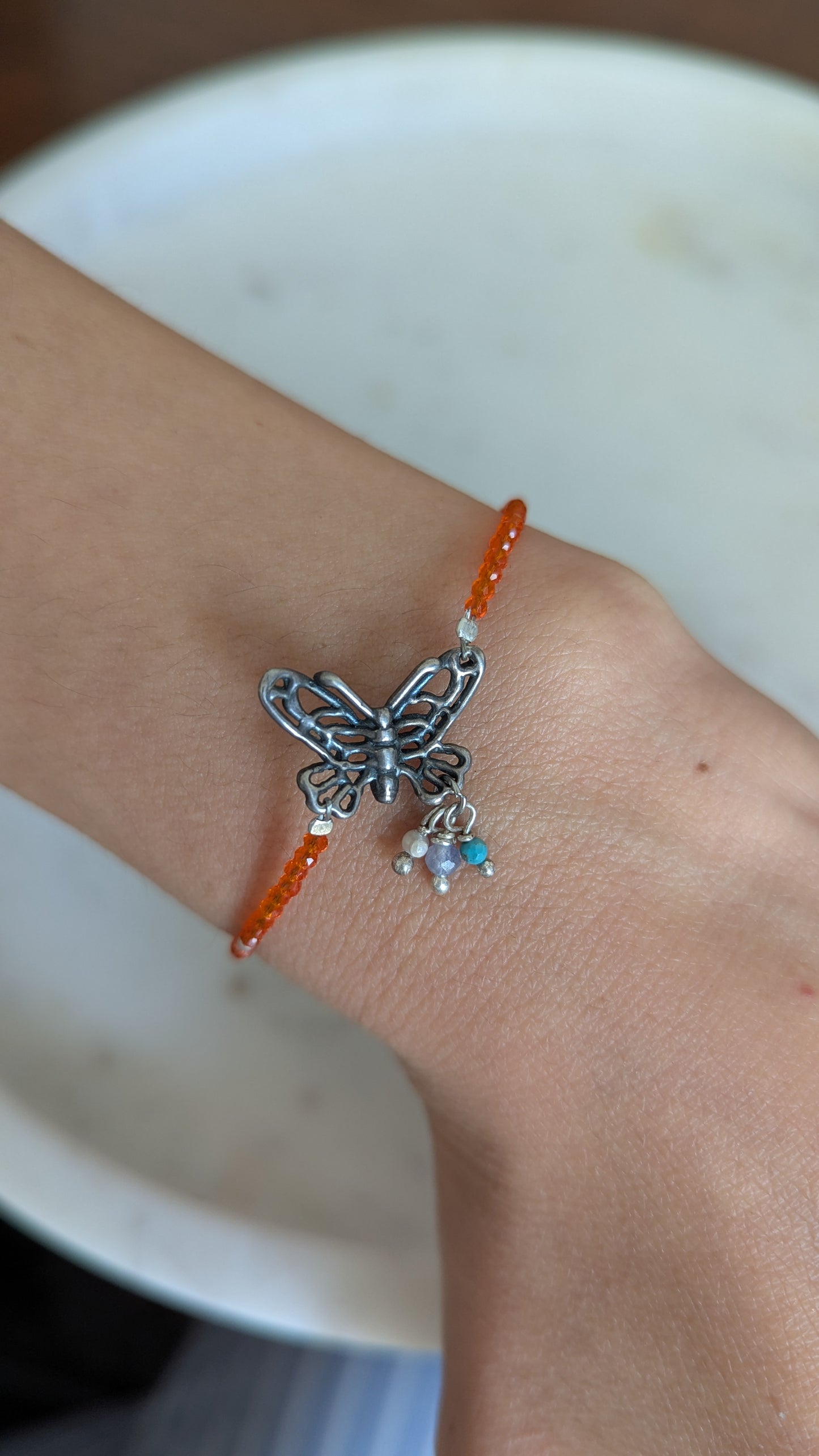 Pulsera piedras naturales con mariposa al centro.